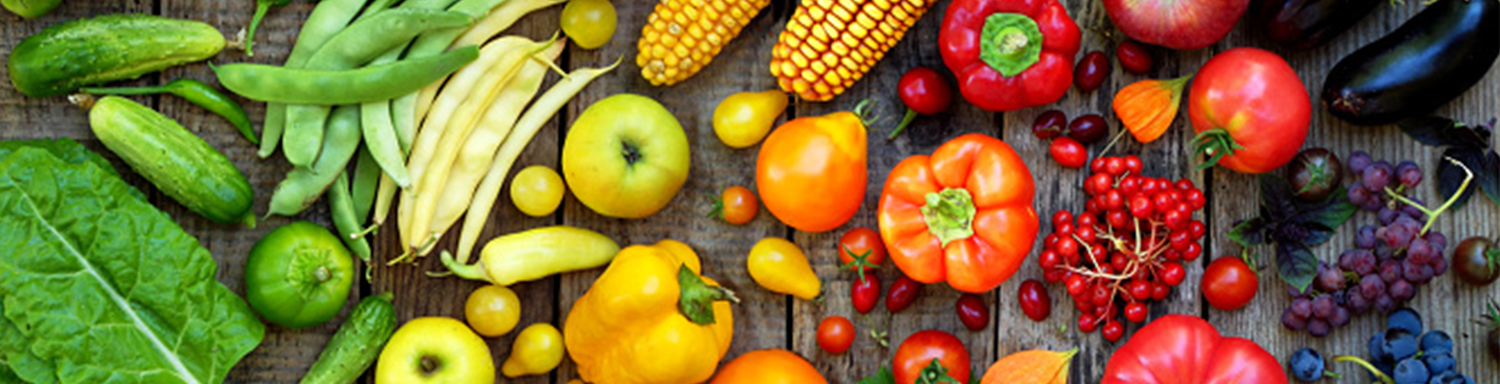 A variety of brightly colored vegetables laid out on a wooden table