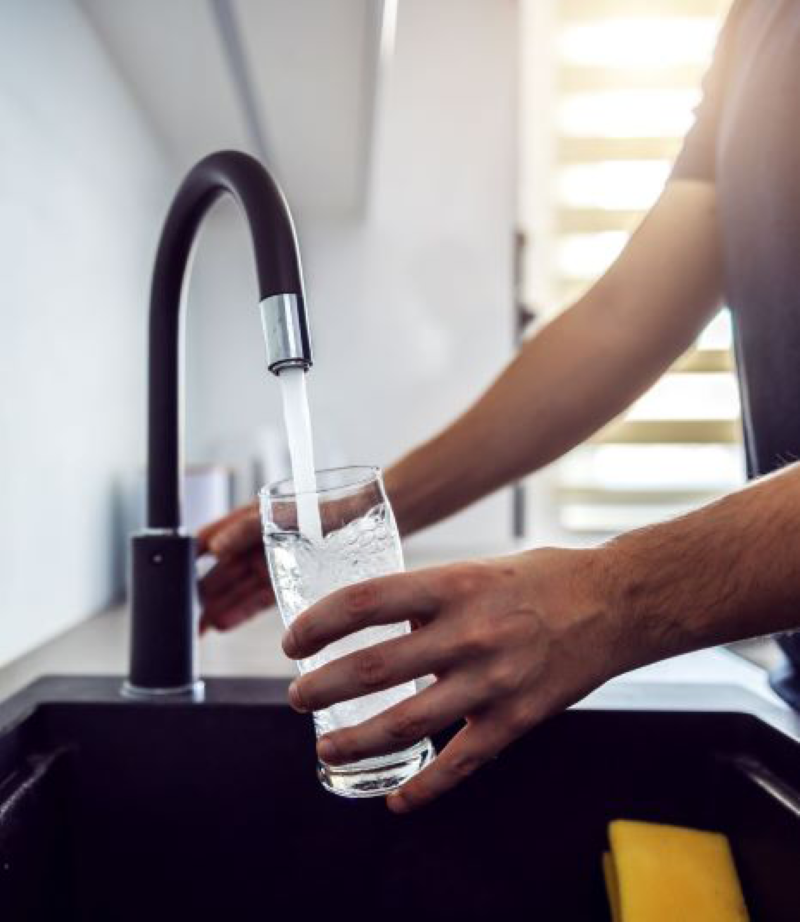 Someone filling up water glass