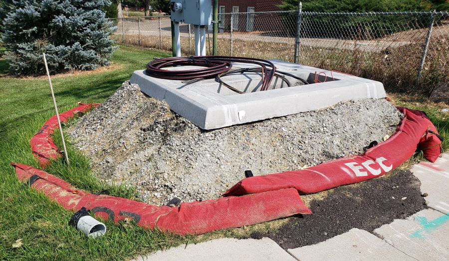 Construction site with sandbags surrounding a concrete sludge pile, preventing runoff