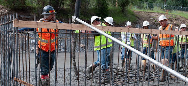 Group of multi-ethnic construction workers pouring cement during a project.