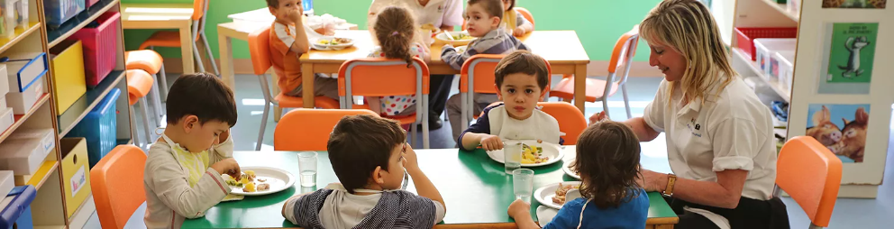 Children in daycare eating at a table together