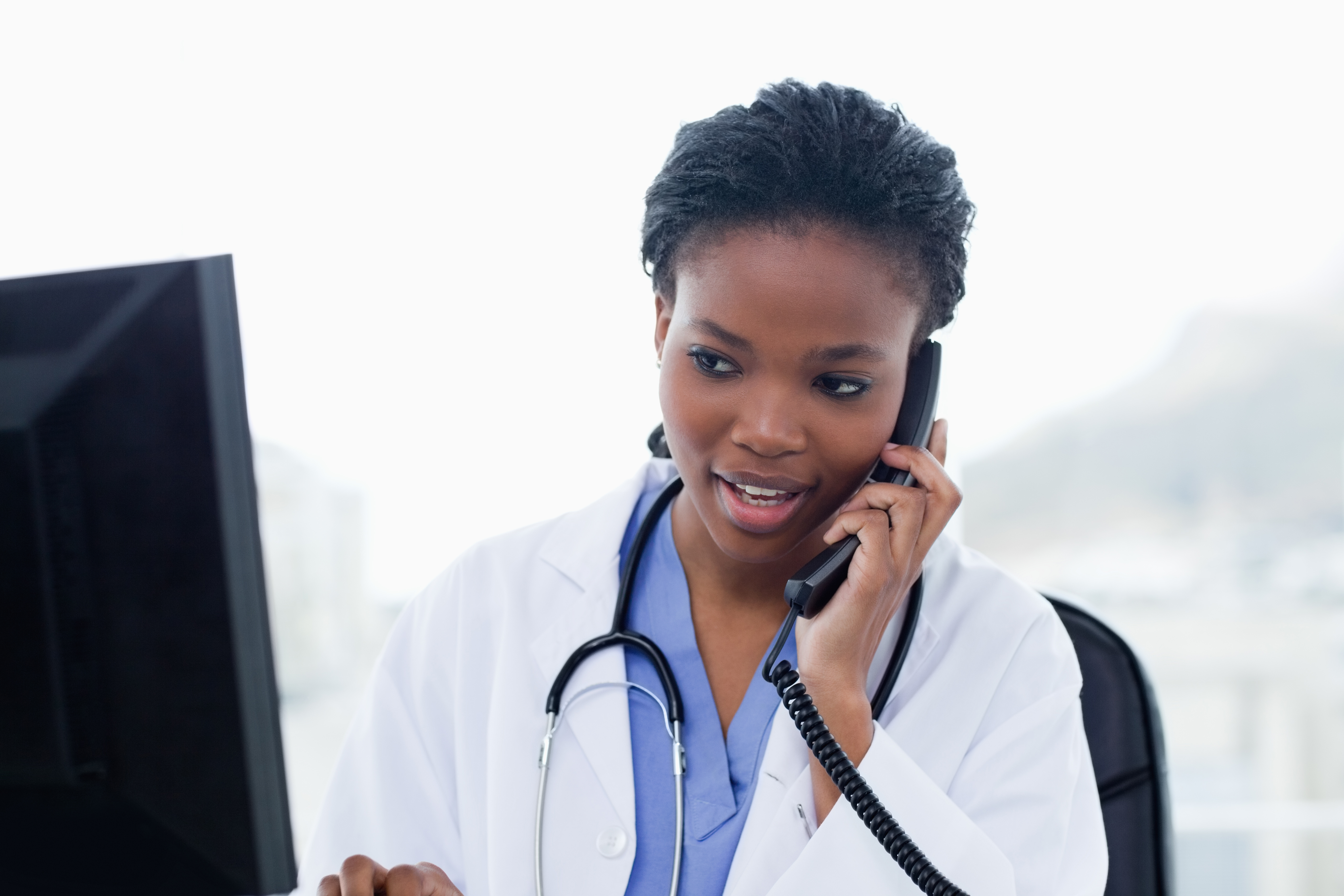 doctor on phone in front of computer monitor