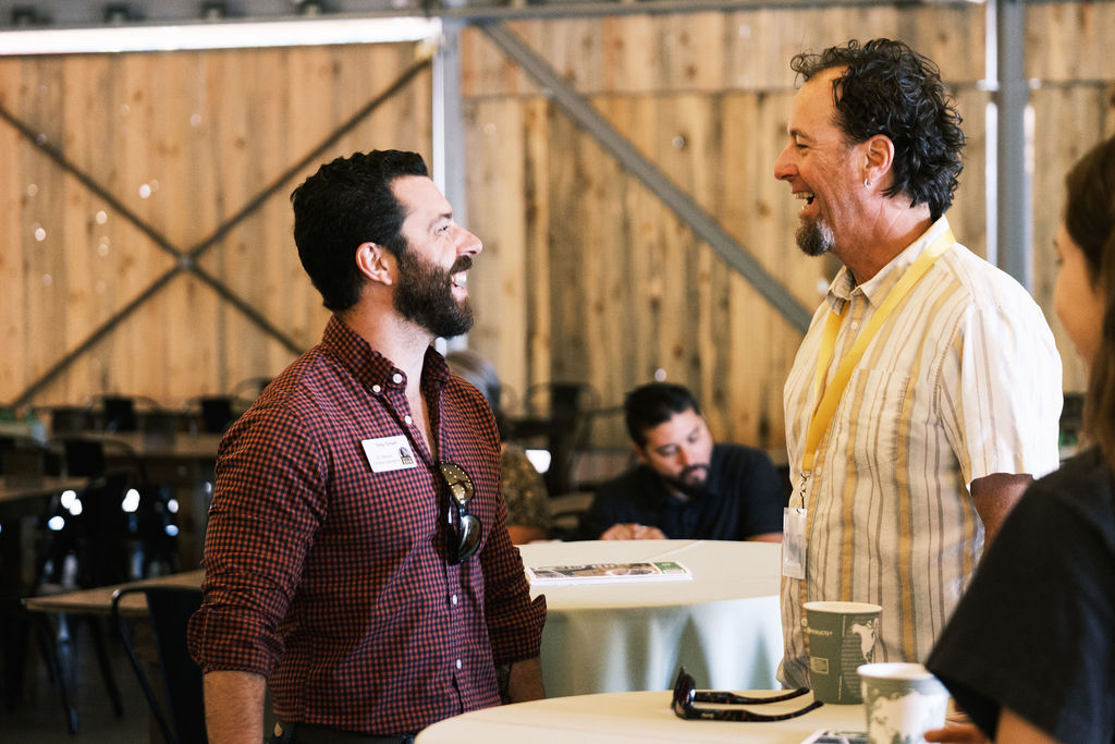 Two people laughing at each other during the networking hour at the 2023 CGBN Recognition Event.