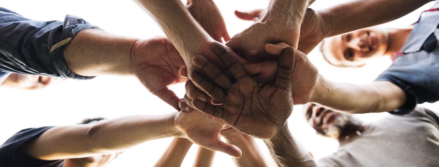 group touching hands in solidarity