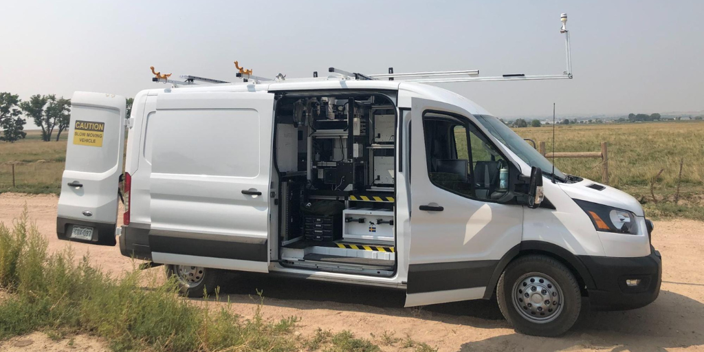 Mobile Optical Oil and gas Sensor of Emissions mobile monitoring van with doors open to display the air monitoring instruments inside.