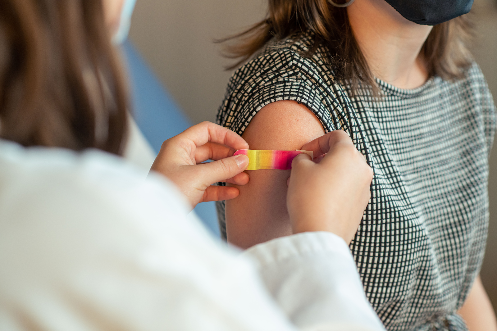 a bandaid is placed on someone's shoulder