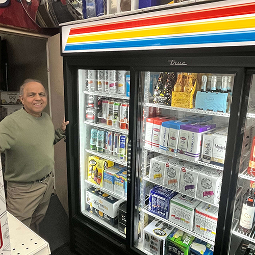 Aurora Liquor owner pictured with their new efficient refrigeration equipment.