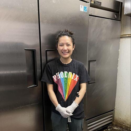 A Golden Saigon Restaurant employee standing in front of their new Energy Star freezer