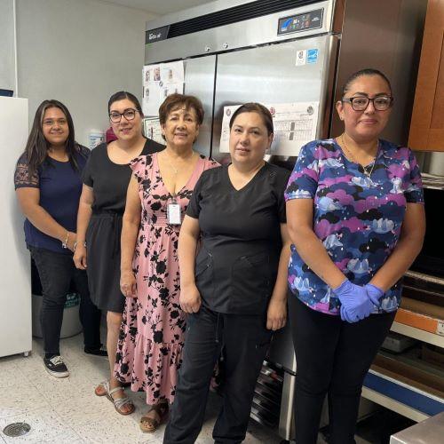 5 members of Little Giants Learning Center staff standing in front of their new 2-door Energy Star refrigerator