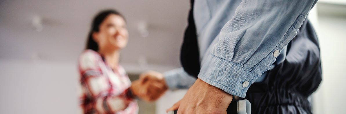 A radon contractor shaking hands with a homeowner.